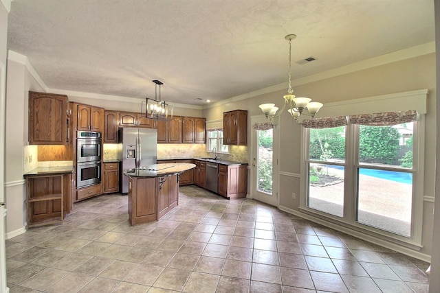 1599 John Ridge Dr, Collierville, TN 38017 - kitchen with a chandelier, appliances with stainless steel finishes, healthy amount of natural light, and ornamental molding