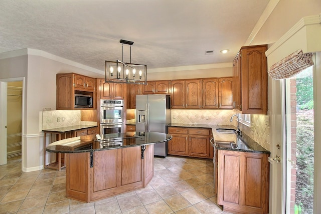 1599 John Ridge Dr, Collierville, TN 38017 - kitchen with appliances with stainless steel finishes, brown cabinets, a sink, and a center island