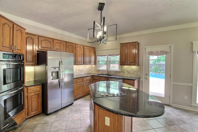 1599 John Ridge Dr, Collierville, TN 38017 - kitchen with appliances with stainless steel finishes, a sink, brown cabinets, and a chandelier