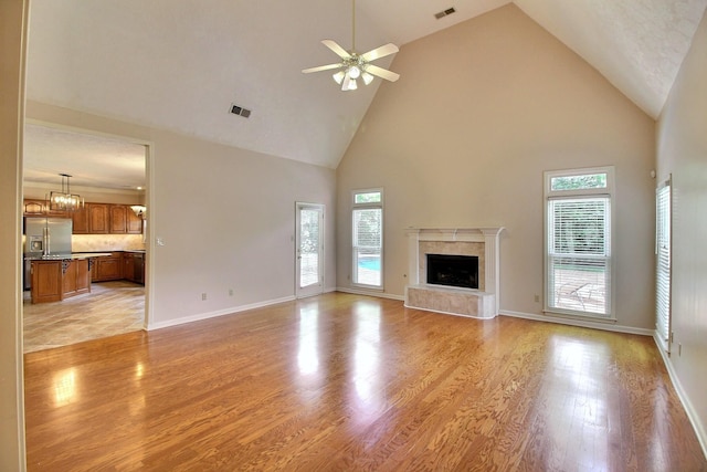 1599 John Ridge Dr, Collierville, TN 38017 - unfurnished living room featuring high vaulted ceiling, light wood-type flooring, ceiling fan, a fireplace, and baseboards