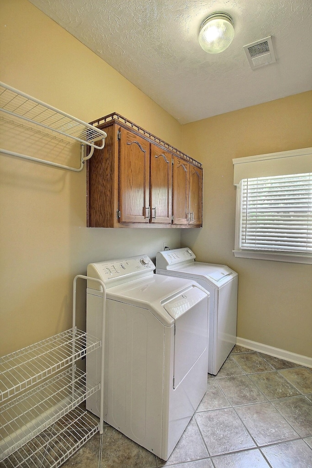 1599 John Ridge Dr, Collierville, TN 38017 - laundry room featuring separate washer and dryer, cabinet space, baseboards, and a textured ceiling