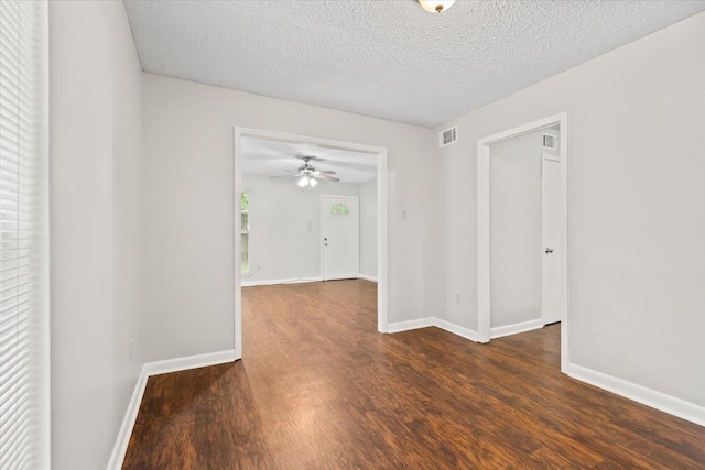 unfurnished room with wood finished floors, baseboards, a ceiling fan, and a textured ceiling