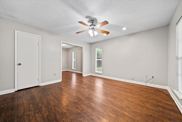 unfurnished room featuring ceiling fan, wood finished floors, a textured ceiling, and baseboards