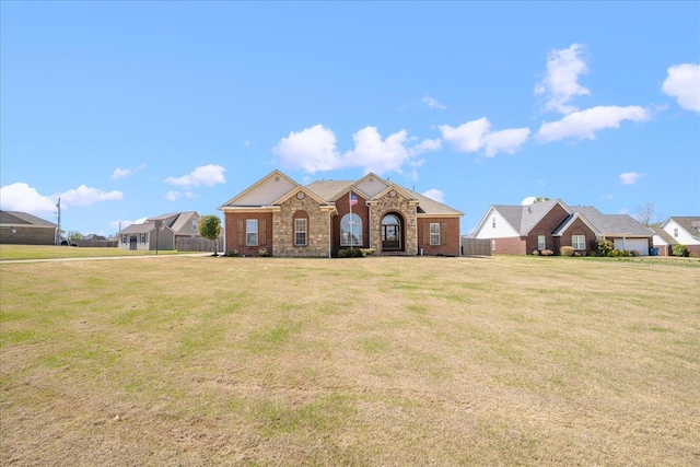 view of front of house with a front yard and brick siding