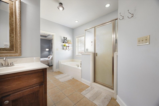 ensuite bathroom with tile patterned flooring, vanity, a stall shower, a bath, and baseboards