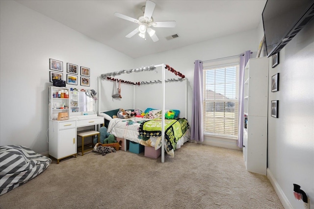 bedroom with light colored carpet, ceiling fan, and baseboards