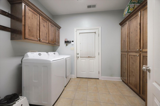 washroom featuring cabinet space, independent washer and dryer, light tile patterned floors, and baseboards