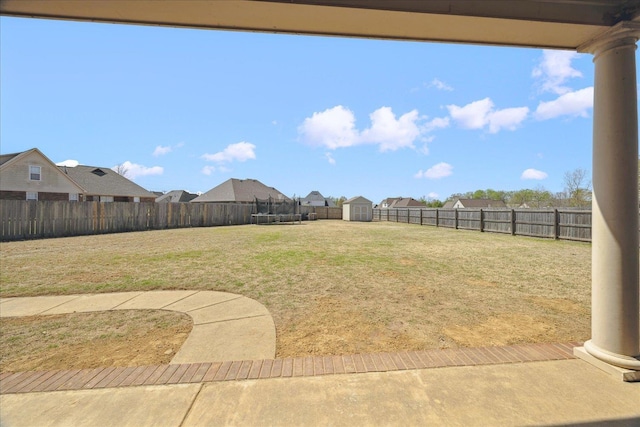 view of yard featuring a shed, an outbuilding, a residential view, and a trampoline
