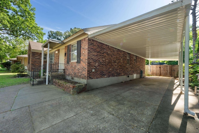 1844 Myrna Ln, Memphis, TN 38117 - view of side of home with brick siding, a carport, driveway, crawl space, and fence