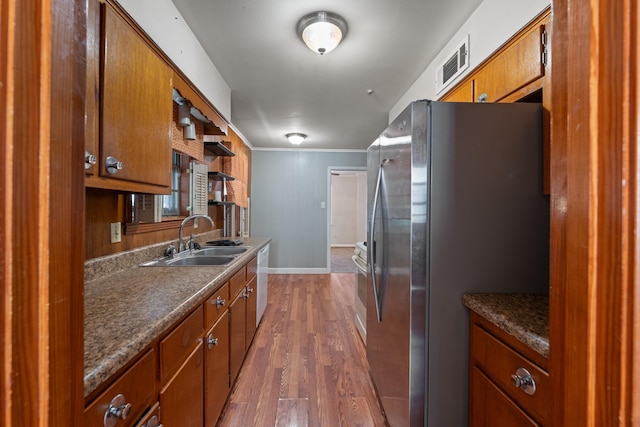 1844 Myrna Ln, Memphis, TN 38117 - kitchen with stainless steel fridge, a sink, white dishwasher, brown cabinets, and dark wood finished floors