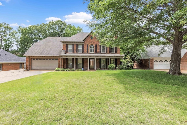 345 Locust Grove Grv, Memphis, TN 38018 - colonial house featuring brick siding, a porch, a garage, a front yard, and driveway