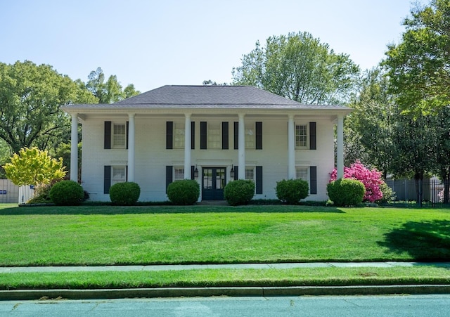 greek revival house with french doors, brick siding, and covered porch