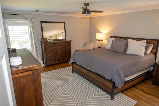 bedroom featuring wood finished floors, ornamental molding, and ceiling fan