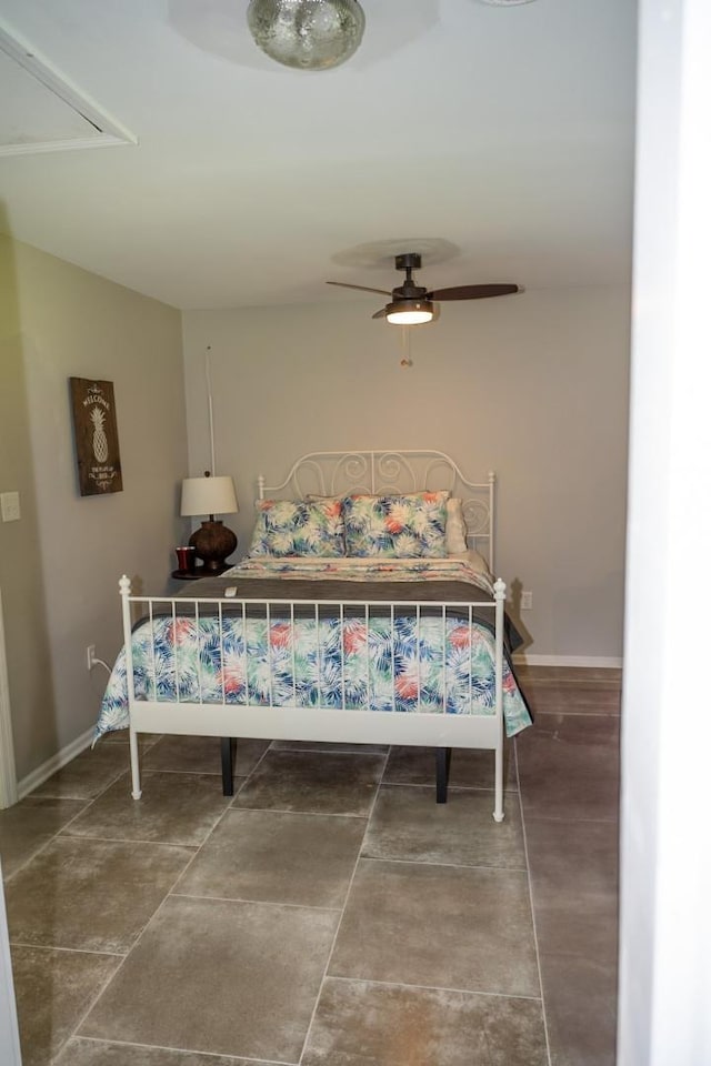 bedroom featuring attic access, baseboards, and a ceiling fan