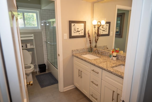 full bathroom featuring toilet, tile patterned flooring, double vanity, shower / bath combination with glass door, and baseboards
