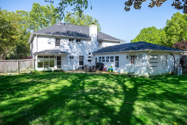 rear view of property with a chimney and a patio area