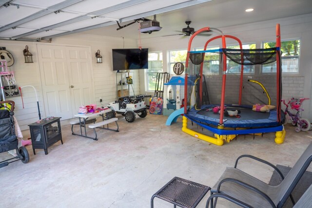 garage featuring a garage door opener, a trampoline, a ceiling fan, and recessed lighting