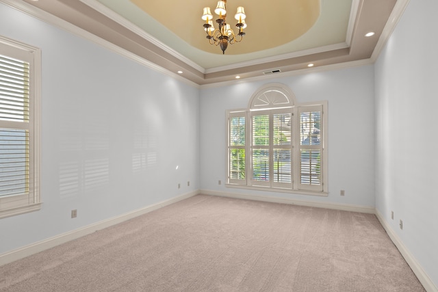 carpeted spare room featuring a chandelier, ornamental molding, a raised ceiling, recessed lighting, and baseboards