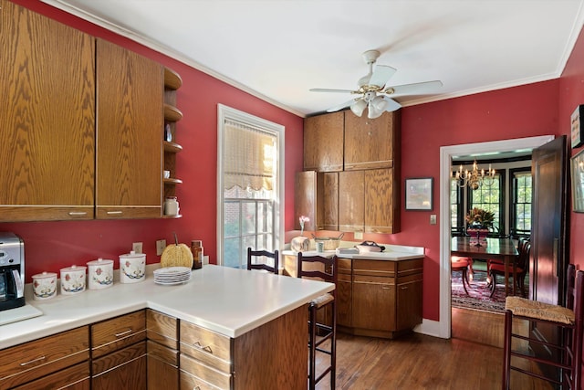 14 Morningside Pl, Memphis, TN 38104 - kitchen featuring ceiling fan, brown cabinetry, dark wood finished floors, light countertops, and a breakfast bar area