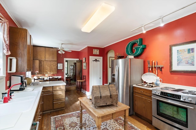 14 Morningside Pl, Memphis, TN 38104 - kitchen featuring appliances with stainless steel finishes, brown cabinets, wood finished floors, light countertops, and ornamental molding