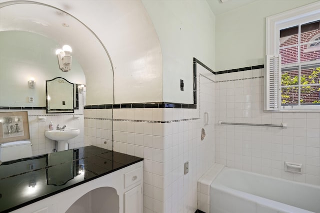 14 Morningside Pl, Memphis, TN 38104 - bathroom with tile walls, a tub, a wainscoted wall, and a sink