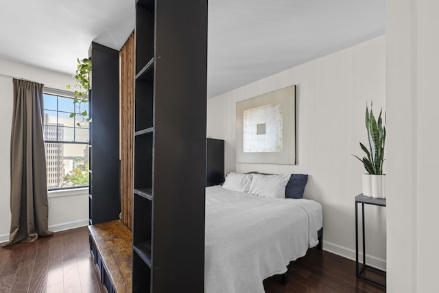 bedroom featuring dark wood finished floors and baseboards