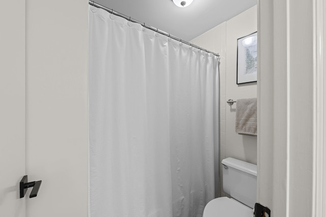 full bath with toilet and curtained shower