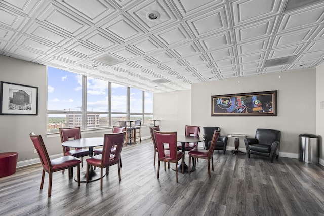 dining area featuring an ornate ceiling, healthy amount of natural light, dark wood-style flooring, and baseboards