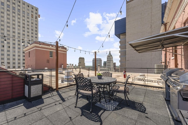 view of patio / terrace with a city view, a balcony, a grill, and outdoor dining area