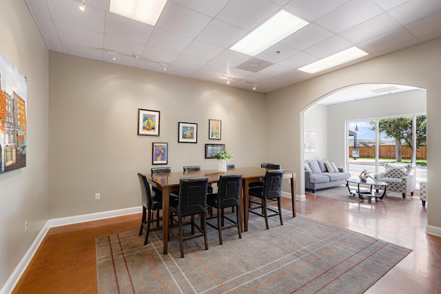 510 Cityhouse Ct Unit 406, Memphis, TN 38103 - dining space featuring track lighting, arched walkways, baseboards, and a paneled ceiling