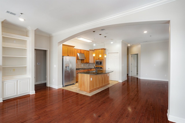 510 Cityhouse Ct Unit 406, Memphis, TN 38103 - kitchen with stainless steel appliances, under cabinet range hood, arched walkways, a center island with sink, and backsplash