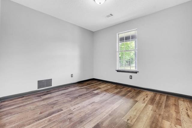 spare room featuring hardwood / wood-style floors and baseboards