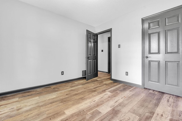 unfurnished bedroom featuring light wood-style flooring and baseboards