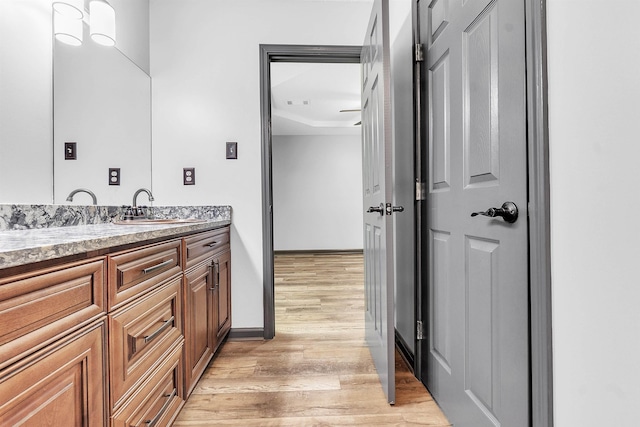 bathroom featuring wood finished floors, vanity, and baseboards