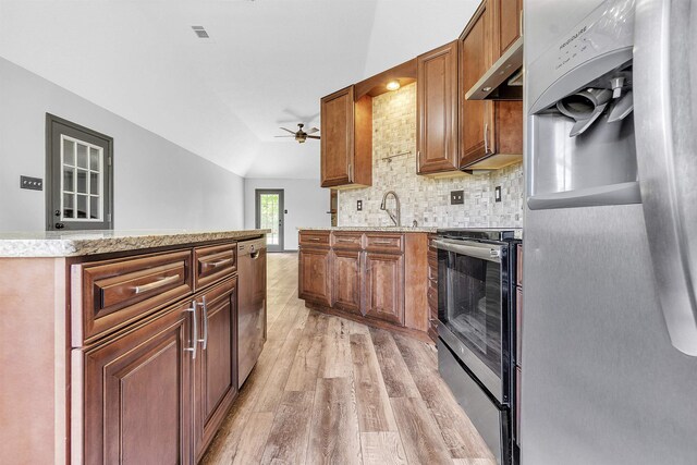 kitchen with range hood, light wood-style flooring, stainless steel appliances, lofted ceiling, and decorative backsplash