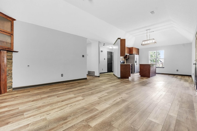 unfurnished living room featuring lofted ceiling, light wood-style flooring, and baseboards