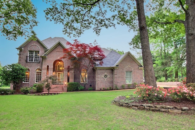 traditional-style home featuring brick siding and a front yard