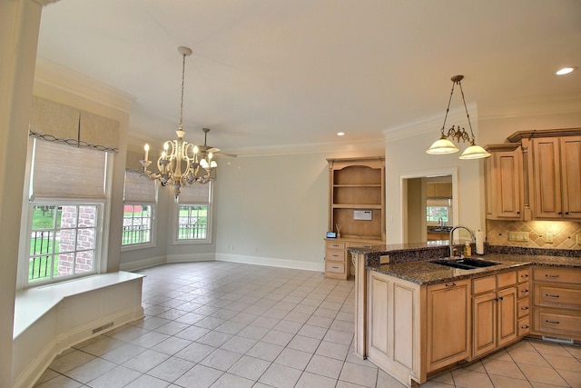 kitchen featuring a sink, a chandelier, light tile patterned floors, decorative backsplash, and crown molding