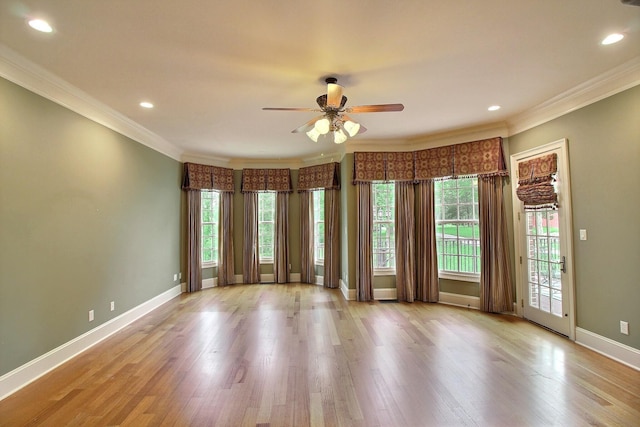 unfurnished room with plenty of natural light, crown molding, a ceiling fan, wood finished floors, and baseboards