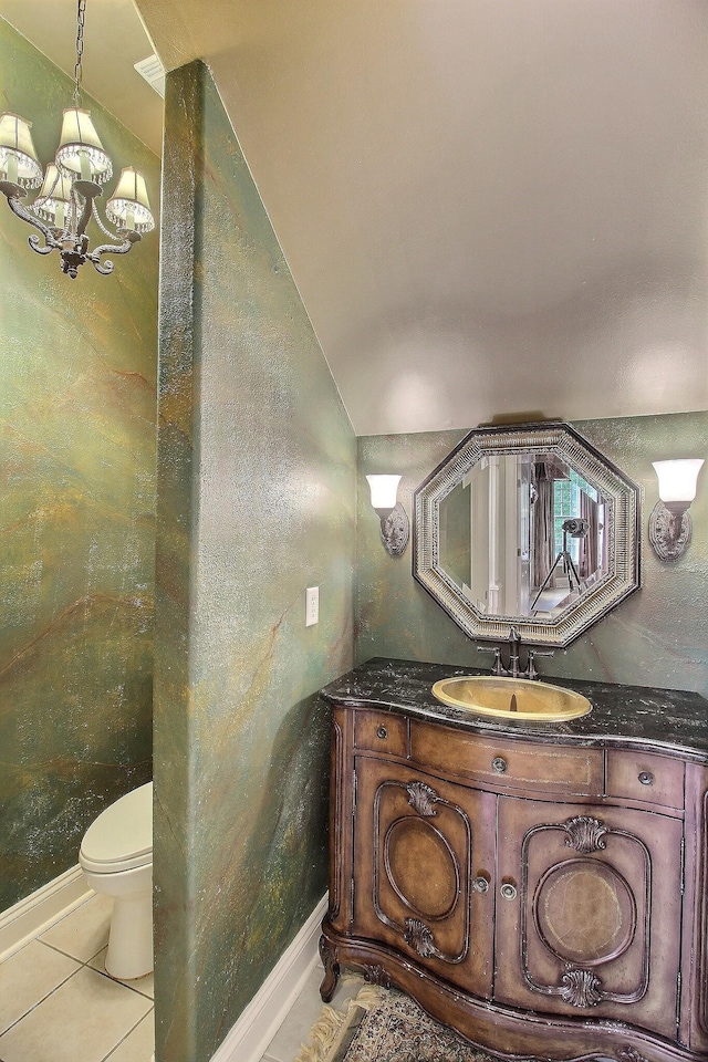 bathroom with a chandelier, tile patterned flooring, toilet, vanity, and vaulted ceiling
