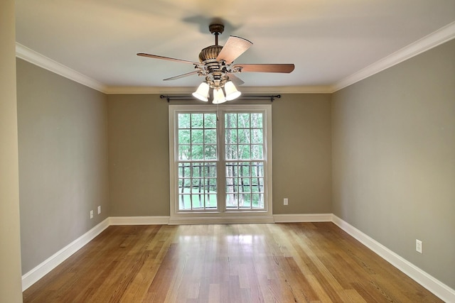 empty room with wood finished floors, baseboards, ceiling fan, and crown molding
