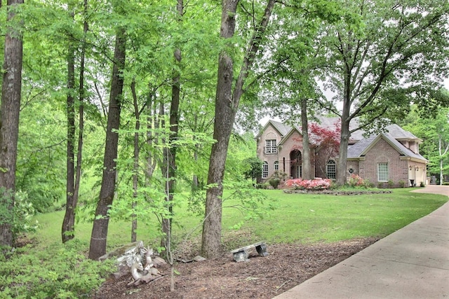 view of front of property with a front lawn, driveway, and brick siding