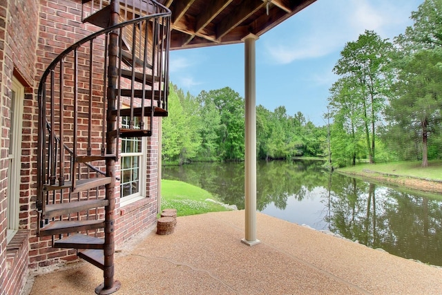 view of patio / terrace featuring a water view and stairway