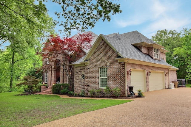 view of front of house with driveway, brick siding, a front lawn, and roof with shingles