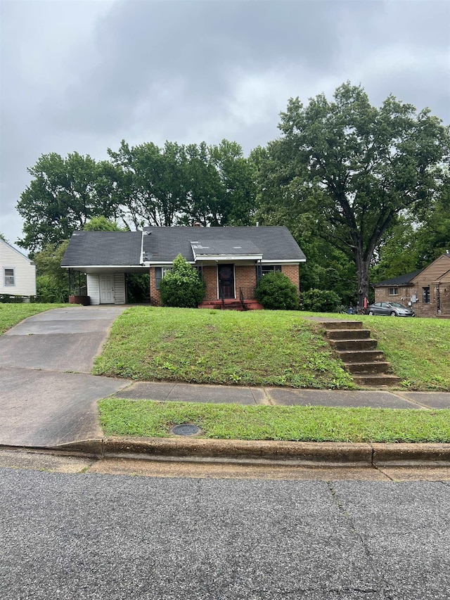 ranch-style house with brick siding, asphalt driveway, a front lawn, and a carport