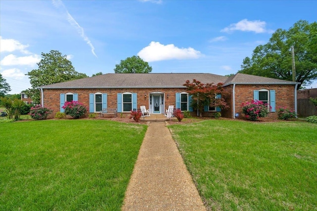 ranch-style house featuring a front yard, brick siding, and a shingled roof