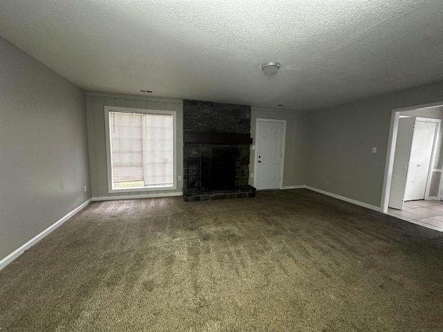 2980 Ridgeway Dr, Memphis, TN 38115 - unfurnished living room with a textured ceiling, carpet flooring, a stone fireplace, and baseboards