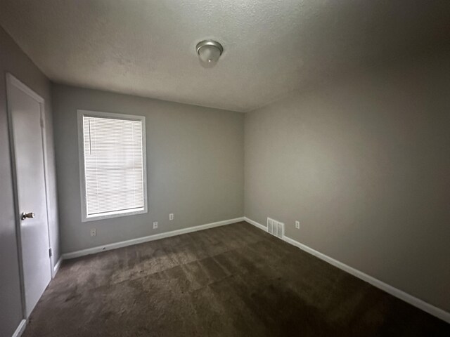 2980 Ridgeway Dr, Memphis, TN 38115 - empty room featuring dark colored carpet, baseboards, and a textured ceiling