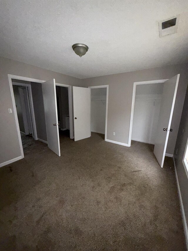 2980 Ridgeway Dr, Memphis, TN 38115 - unfurnished bedroom featuring two closets, dark colored carpet, and baseboards