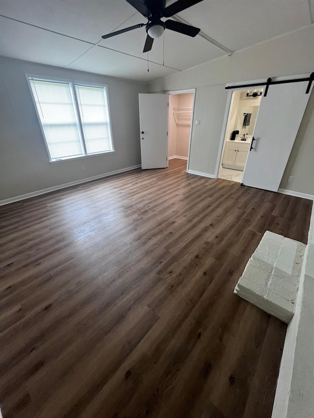 2902 Capri St, Memphis, TN 38118 - unfurnished living room with ceiling fan, a barn door, dark wood-type flooring, and baseboards